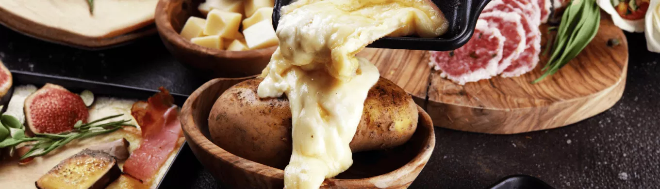 Raclette coulant sur une pomme de terre pour la saison hivernale