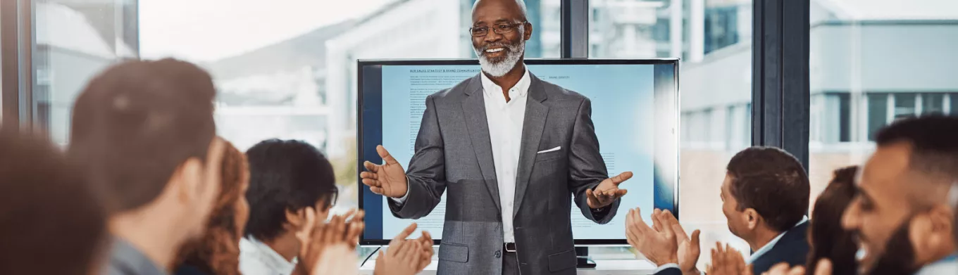 Un employé heureux, applaudi et reconnu par ses collègues